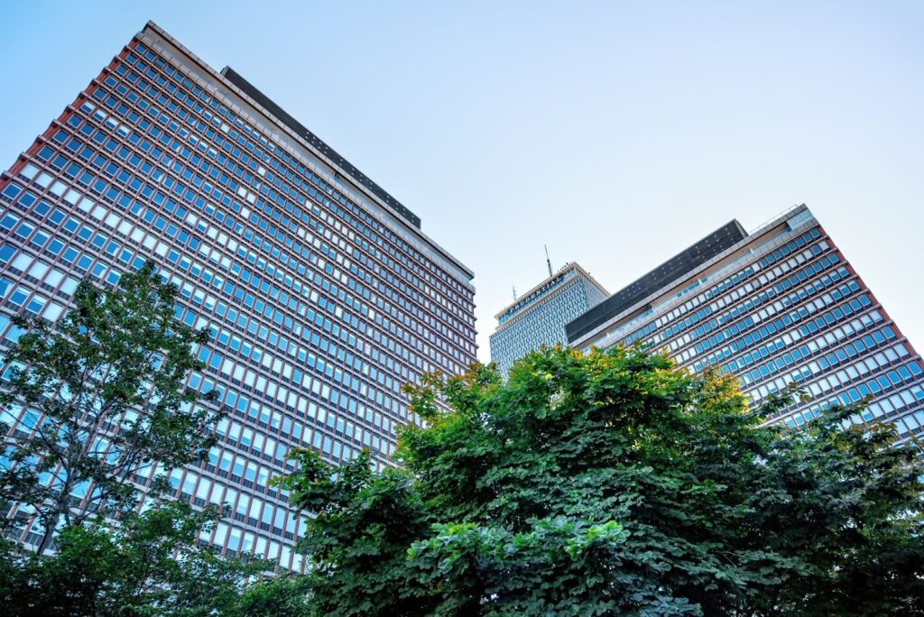 波士頓保德信大廈（Prudential Tower）附近的高樓大廈仰視圖/現代主義建築與窗格設計/城市摩天大樓與綠樹景觀/美國波士頓建築