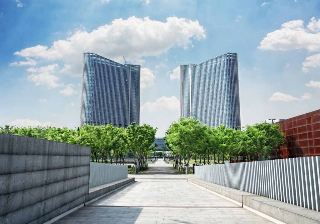 兩棟對稱的現代高樓大廈與綠樹步道/城市商業區與公園景觀/都市建築設計和綠化空間/商業中心或總部大樓